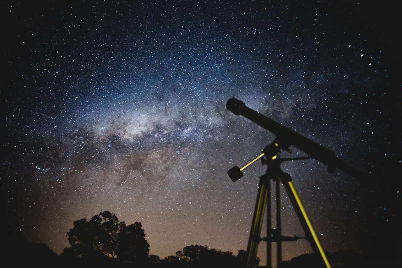 Stunning starry sky with silhouette of telescope capturing the Milky Way in Brazil.